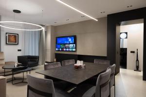 una sala da pranzo con tavolo, sedie e TV di 1006 Grand Residence - 4pers a Bucarest Altre 7 foto