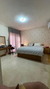 アンマンにあるzainab houseのベッドと机と窓のある寝室