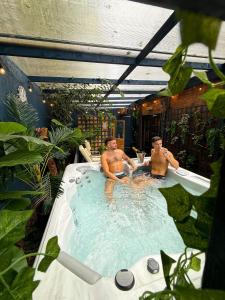 two men are sitting in a bath tub at The Old Hunting Lodge at The Talbot Inn in Tenbury
