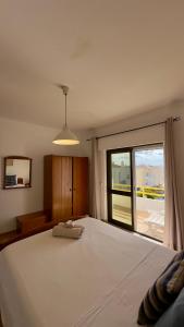 una camera da letto con un grande letto bianco con una finestra di Sea View Apartment in Altura, Algarve 300m from Beach and Town Center ad Altura