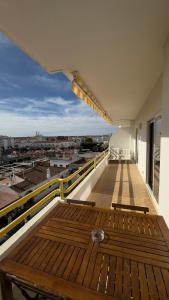 un balcone con panca in legno in cima a un edificio di Sea View Apartment in Altura, Algarve 300m from Beach and Town Center ad Altura Altre 6 foto