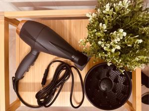 a black hair dryer on a shelf next to a plant at Foresta Living in Mendrisio