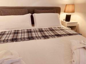 a large bed with white sheets and pillows at Foresta Living in Mendrisio