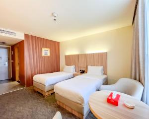 una habitación de hotel con dos camas y una mesa en La Casa Hotel Amman by FHM, en Amán