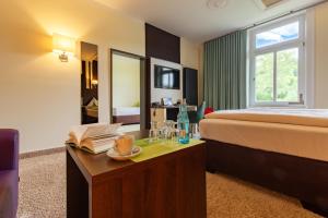 Bad RehburgにあるParkhotel Bad Rehburgのベッド、テーブル、トレイ(グラス付)が備わる客室です。