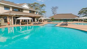 une grande piscine bleue avec chaises et parasols dans l'établissement Lake Naivasha Resort, à Naivasha