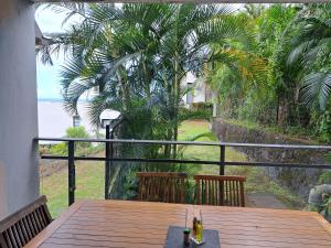 Una mesa en un balcón con vista al mar. en L'ETANG SALE APPART 2 CHAMBRES, en Étang-Salé
