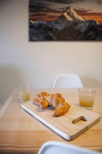 un tavolo con due croissant e due bicchieri di succo d'arancia di El mirador de Panticosa l WIFI l Garaje l Vistas a Panticosa