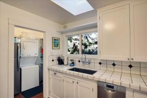 a kitchen with white cabinets and a sink and a window at Hammonds Beach Haven in Santa Barbara +45 photos