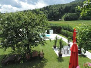 a garden with a tree and an umbrella at Schwanbergerstüberl in Schwanberg