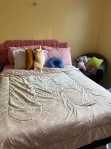 two stuffed animals sitting on top of a bed at Casa Confort Belém in Belém