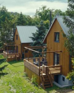 a large wooden house with a porch and a deck at Chaty Břeh a Les in Louka