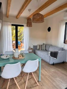 a living room with a blue table and white chairs at Chaty Břeh a Les in Louka +21 photos