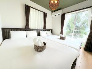 a bedroom with two beds with white sheets and a window at The feel Kincho cho Seaside villa - sea - / Vacation STAY 26186 in Yaka