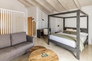 een slaapkamer met een bed, een bank en een tafel bij L'Anxana in Formiche Alto