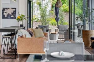 a living room with a couch and a table at Boutique Coastal Retreat with Bath Walk to Beach in Mangawhai