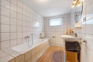 NeubulachにあるFerienwohnung Maliaの浴槽と洗面台のある白いバスルーム