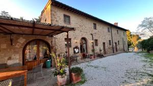 a large stone building with a patio in front of it at Antica Colombaia in Volterra