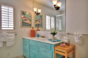 Un baño con un lavabo azul y un espejo. en West Beach Villas 1 & 2, en Santa Bárbara 56 fotos más