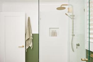 a shower with a glass door in a bathroom at Oak Ridge Cottage in Maleny +10 photos