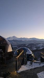 een met sneeuw bedekt terras met tenten bovenop een berg bij Bubble Sky Villas Kosove in Ferizaj