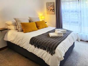 a bedroom with a large bed with towels on it at In Vrede in George