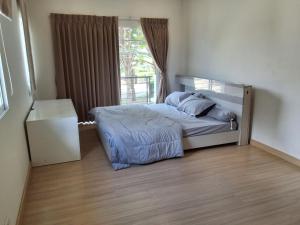 a bedroom with a bed and a window at Spacious Entire House with shared Fitness Room and Shared Indoor Pool in club in Pathum Thani