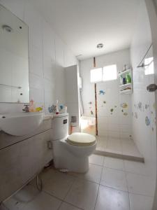 a white bathroom with a toilet and a sink at Spacious Entire House with shared Fitness Room and Shared Indoor Pool in club in Pathum Thani