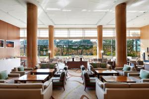 a restaurant with tables and chairs and large windows at Hilton Gyeongju in Gyeongju