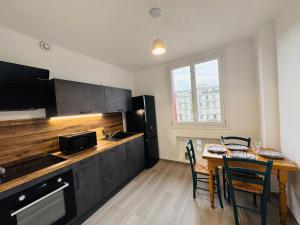 a kitchen with a wooden counter and a table with chairs at Le Perret -Centre -Authentique -UNESCO in Le Havre