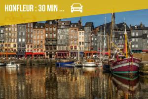 eine Gruppe von Booten, die in einem Hafen mit Gebäuden angedockt sind in der Unterkunft Le Perret -Centre -Authentique -UNESCO in Le Havre