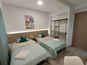 a room with two beds with green sheets at ESTUDIO Villarreal in Villareal