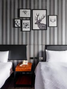 ein Schlafzimmer mit drei Betten und einem Tisch mit Telefon in der Unterkunft Fulidun Hotel Kenting in Altstadt von Hengchun