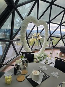 a table with a heart decoration in front of a window at Bubble Sky Villas Kosove in Ferizaj