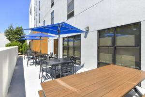 a patio with tables and chairs with blue umbrellas at Hampton Inn & Suites Burlington in Burlington