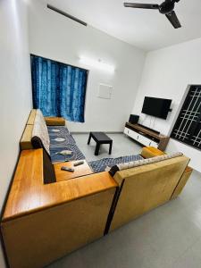 a large couch in a living room with a tv at Licence To Chill Homestay Villa in Pūvār