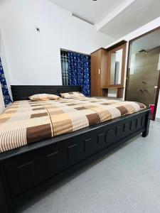 a bedroom with a large bed in a room at Licence To Chill Homestay Villa in Pūvār