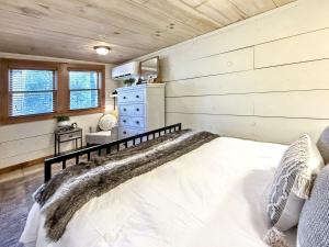 a bedroom with a bed and a dresser in a room at 1930's Highlands Hideaway in Highlands