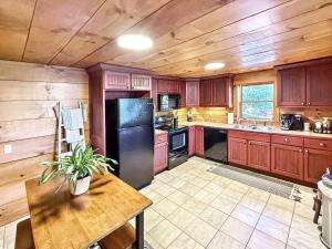 a kitchen with wooden cabinets and a black refrigerator at 1930's Highlands Hideaway in Highlands