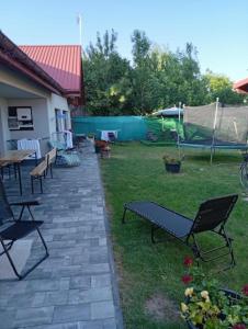 a patio with chairs and a table in a yard at Zakątek Roztocze pokoje gościnne in Zwierzyniec