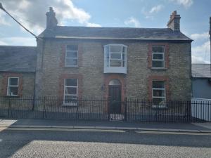 una casa de ladrillo con una valla delante en Moorefield Villa Newbridge, en Newbridge