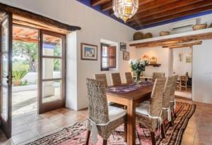 een eetkamer met een houten tafel en stoelen bij Villa Andreuet in Playa Aguas Bancas