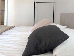 a bed with two pillows on top of it at Henniina V Keskusta - Free Parking in Oulu