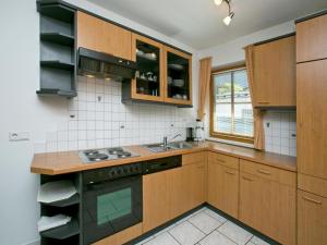 een keuken met houten kasten en een spoelbak bij Apartment in Längenfeld near Ski Slopes in Längenfeld