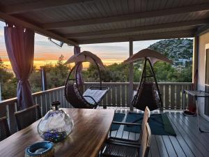 a table and chairs on a porch with a view at GF Mobilehomes Kroatien in Drage