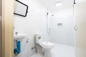 Un baño blanco con inodoro y ducha. en GO INN Siriraj Wang Lang - โก อินน์ ศิริราช ตลาดวังหลัง Pro, en Bangkok Noi