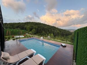 een zwembad met twee stoelen op een houten terras bij Paradise bungalov in Kocaeli