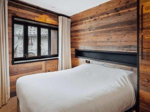 a bedroom with wooden walls and a white bed at Duplex moderne au Casset pour 8 pers avec cheminée et balcon - FR-1-808-10 in Le Monêtier-les-Bains +6 photos