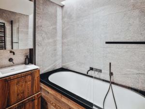 a bathroom with a bath tub and a sink at Duplex moderne au Casset pour 8 pers avec cheminée et balcon - FR-1-808-10 in Le Monêtier-les-Bains