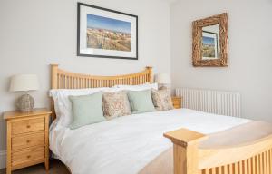 a bedroom with a white bed and a mirror at The Brewer's House in Southwold